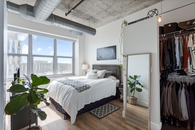 bedroom with wood finished floors and a closet