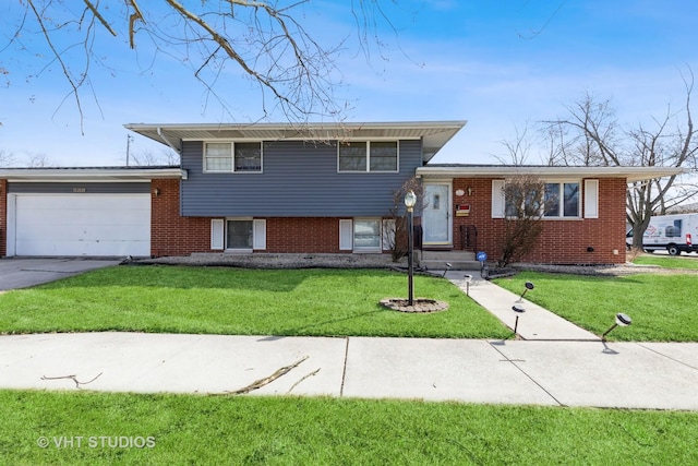 tri-level home with a front lawn, an attached garage, brick siding, and driveway