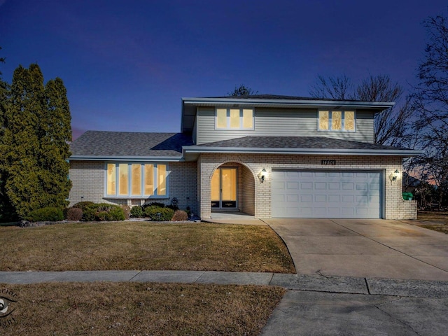 traditional-style house featuring brick siding, a garage, concrete driveway, and a front lawn