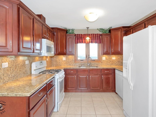 kitchen featuring white appliances, light stone counters, a sink, decorative light fixtures, and tasteful backsplash