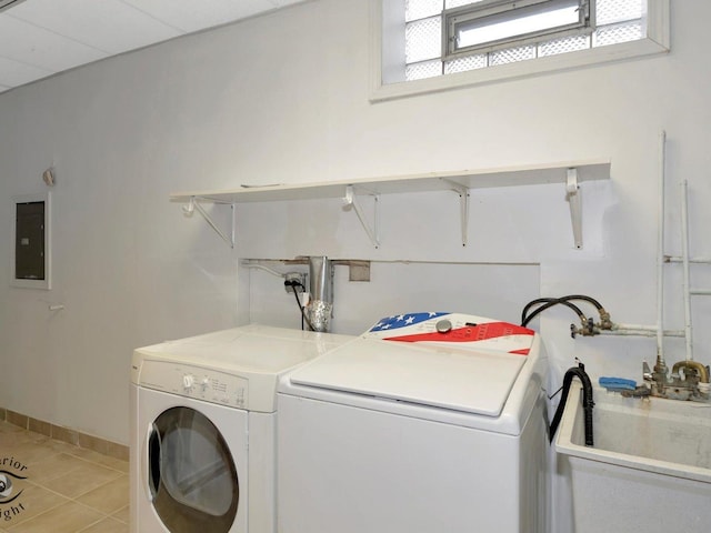 washroom featuring light tile patterned floors, baseboards, laundry area, electric panel, and washer and dryer