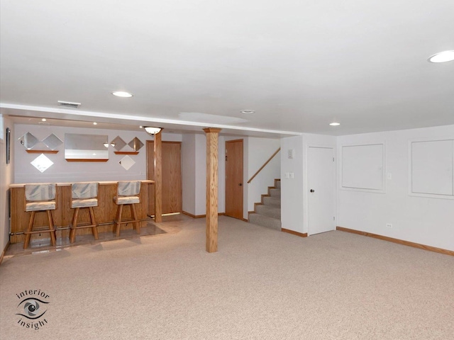 finished basement featuring visible vents, recessed lighting, carpet floors, a dry bar, and stairs