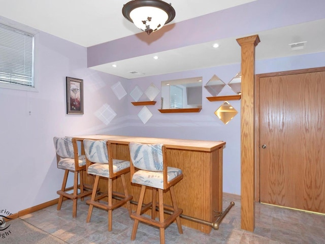 bar with recessed lighting, decorative columns, baseboards, and a dry bar