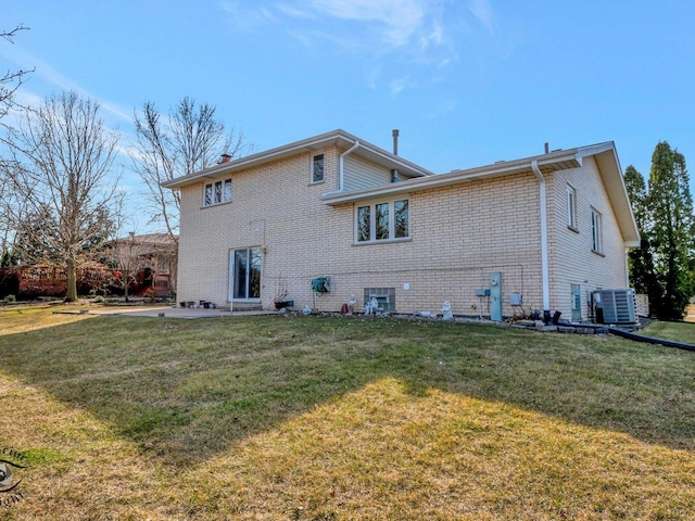 back of house with cooling unit, a patio, a yard, and brick siding