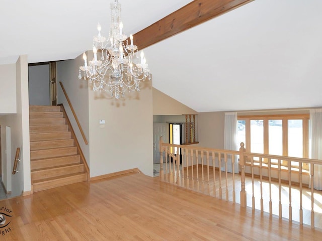 interior space featuring an inviting chandelier, beamed ceiling, wood finished floors, and baseboards