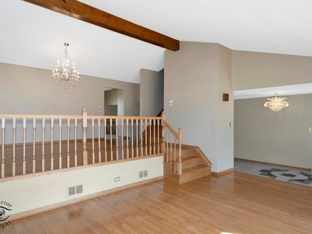 unfurnished room featuring an inviting chandelier, stairway, visible vents, and lofted ceiling with beams