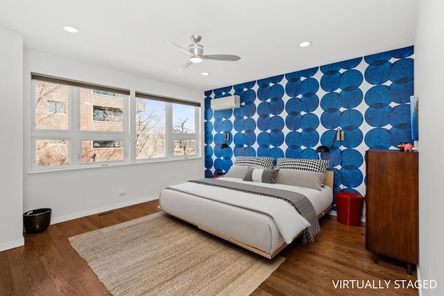 bedroom featuring wood finished floors, recessed lighting, wallpapered walls, baseboards, and an accent wall