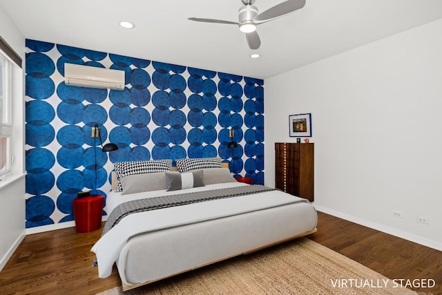 bedroom featuring a wall mounted air conditioner, recessed lighting, wood finished floors, and an accent wall