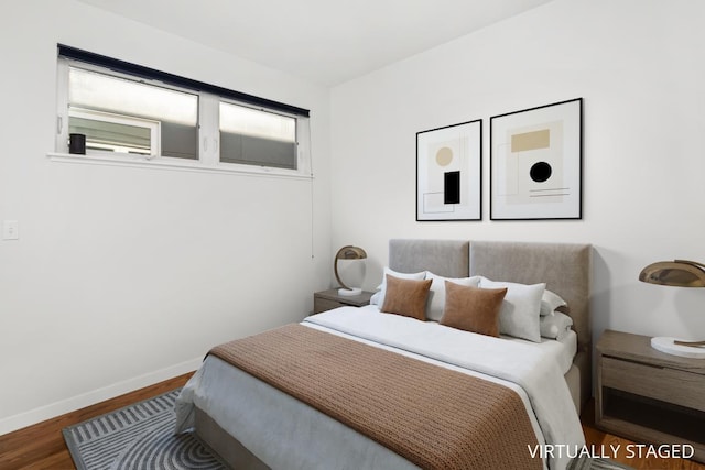 bedroom featuring wood finished floors and baseboards