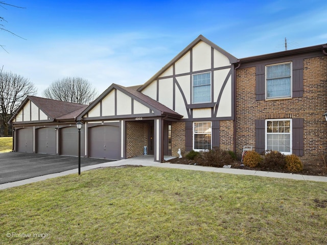 tudor home featuring stucco siding, brick siding, and a front yard