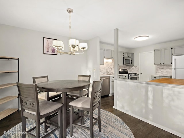 dining room with dark wood-type flooring and a chandelier