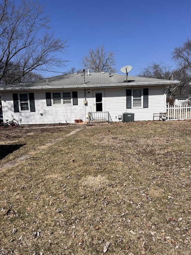 rear view of property featuring central AC unit and fence