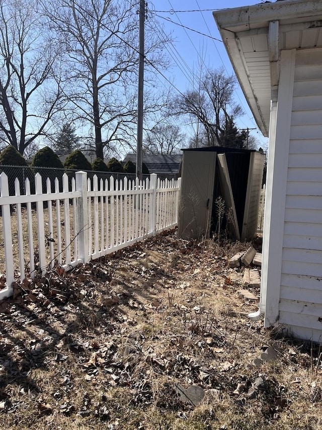 view of yard with fence, an outdoor structure, and a shed