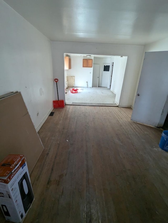 unfurnished living room featuring visible vents and hardwood / wood-style floors