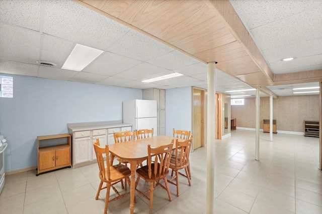 dining room featuring light tile patterned floors, a drop ceiling, baseboards, and visible vents