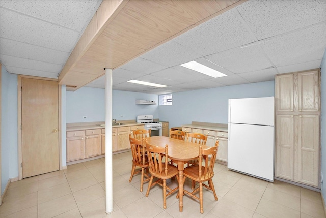 dining room with light tile patterned floors and a paneled ceiling