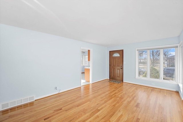 unfurnished living room with visible vents, light wood-style flooring, and baseboards