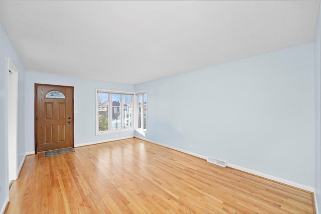 entryway with baseboards, visible vents, and light wood finished floors