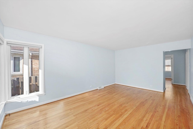 spare room featuring visible vents, baseboards, and light wood-style flooring