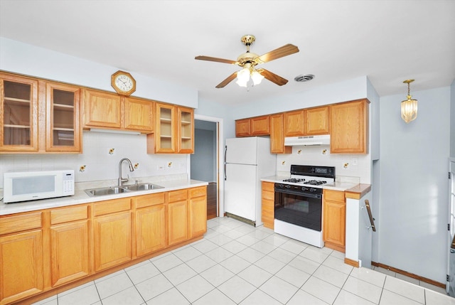 kitchen featuring visible vents, under cabinet range hood, a sink, white appliances, and decorative backsplash