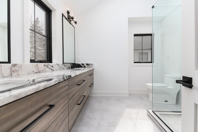 bathroom with double vanity, baseboards, toilet, and a shower