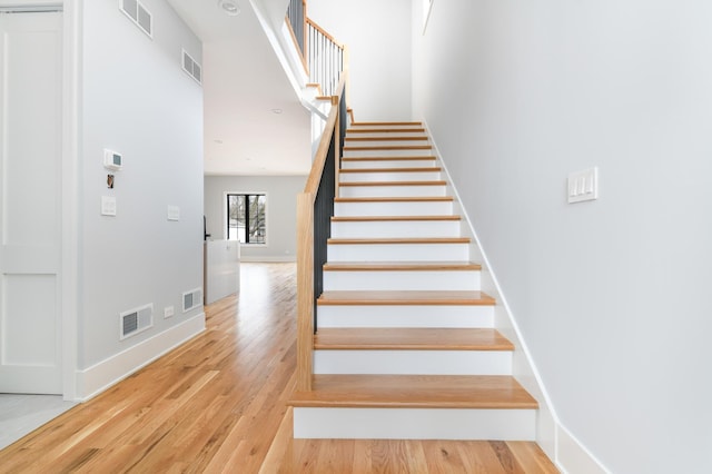 stairs featuring visible vents and wood finished floors