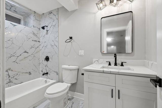 full bathroom with baseboards, shower / washtub combination, toilet, marble finish floor, and vanity