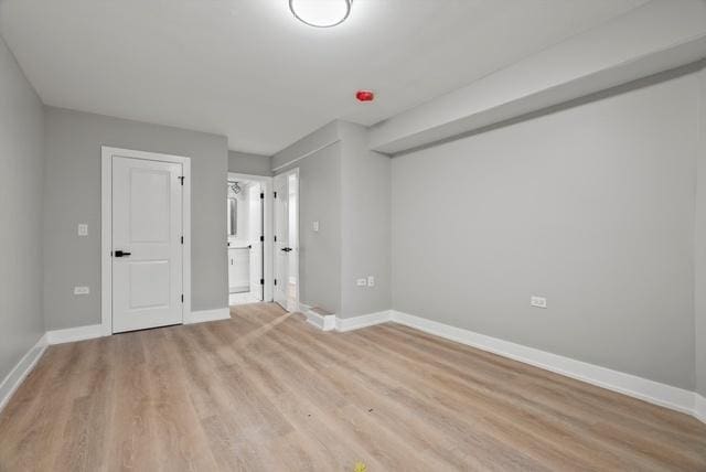 interior space featuring baseboards and light wood finished floors