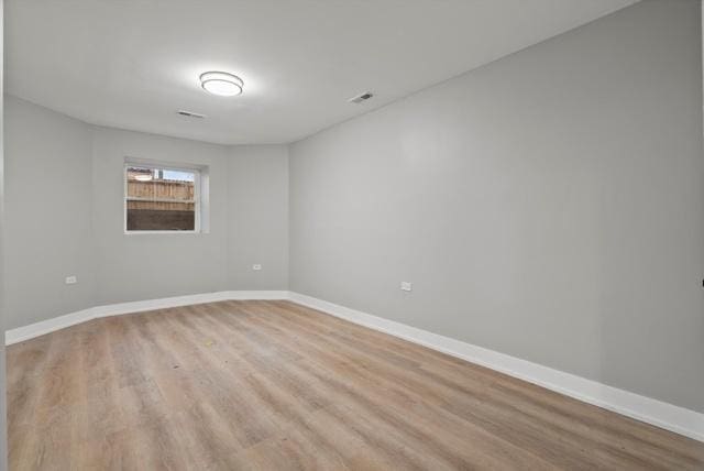 spare room featuring visible vents, baseboards, and light wood-type flooring