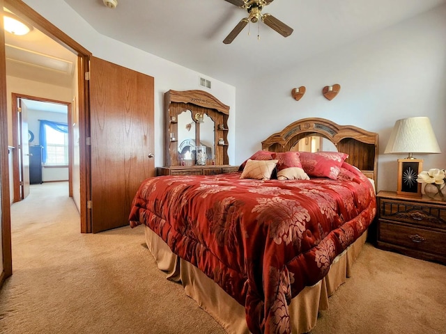 carpeted bedroom with visible vents and ceiling fan