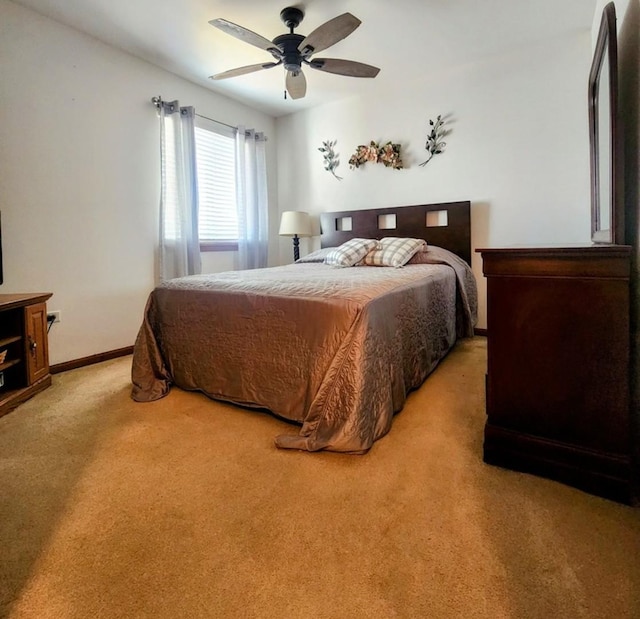 bedroom featuring baseboards, light colored carpet, and ceiling fan