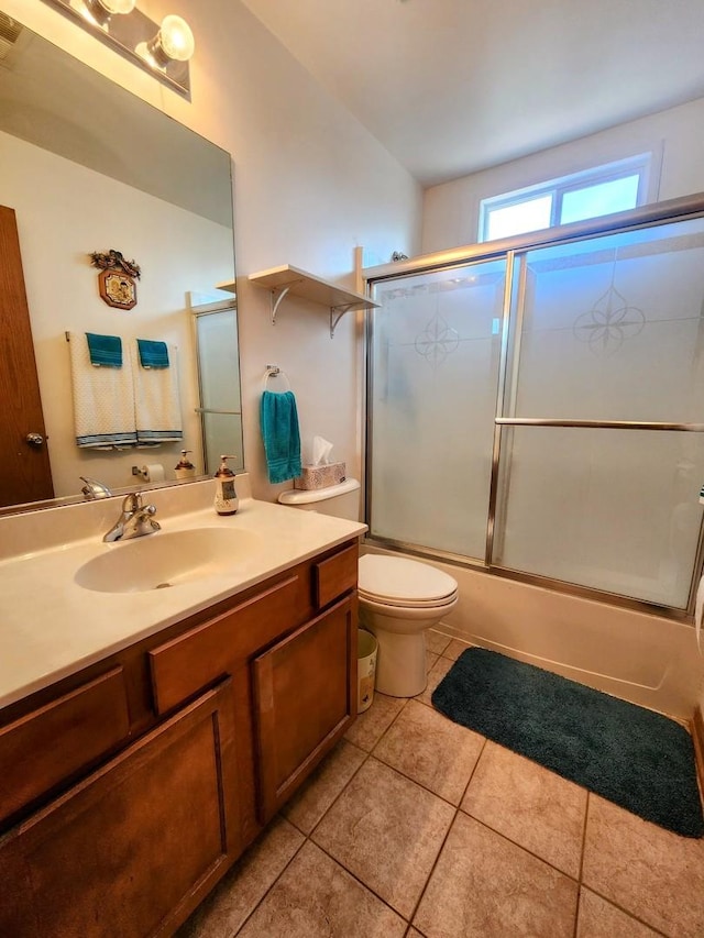 full bathroom featuring tile patterned floors, toilet, vanity, and bath / shower combo with glass door