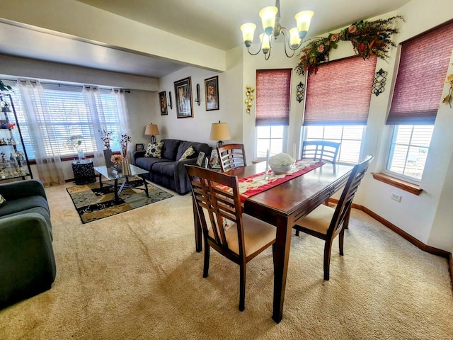 dining area with plenty of natural light, a notable chandelier, and carpet flooring