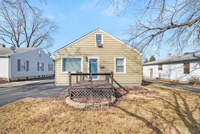 view of front of home with a wooden deck, a front yard, and driveway