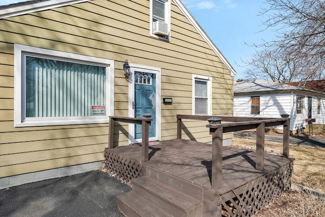 doorway to property featuring cooling unit and a deck