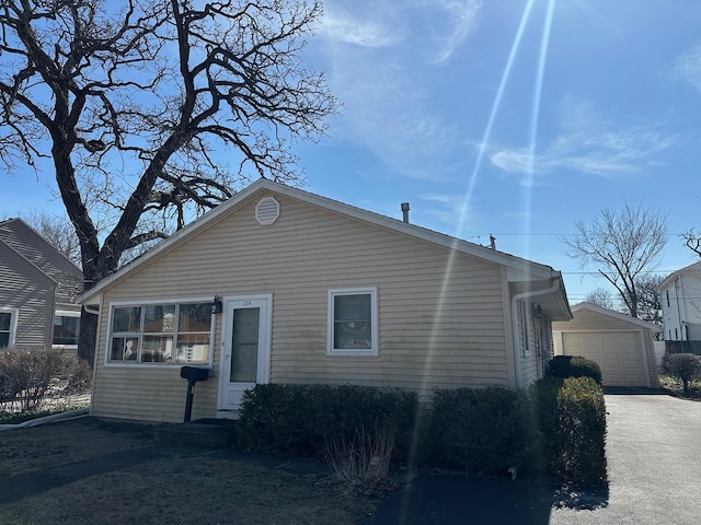 view of front of house with a garage and an outbuilding