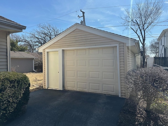 detached garage with fence and driveway