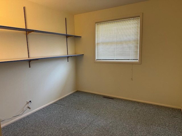 unfurnished room featuring visible vents, baseboards, and carpet flooring