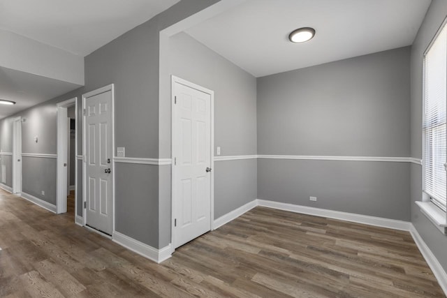 unfurnished room with baseboards and wood finished floors