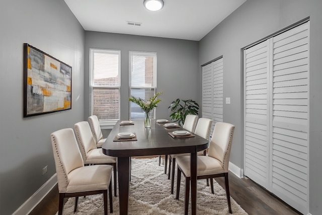 dining area featuring visible vents, baseboards, and dark wood-style flooring