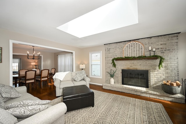 living room featuring a wealth of natural light, a brick fireplace, wood finished floors, and a skylight