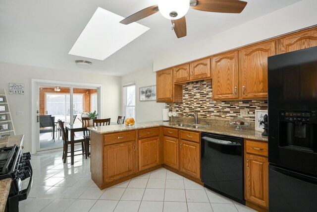 kitchen featuring black appliances, brown cabinetry, and a sink