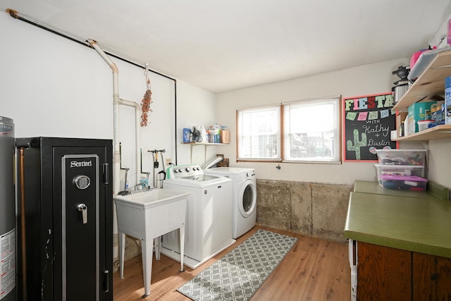 laundry room with laundry area, washing machine and dryer, and light wood-style floors