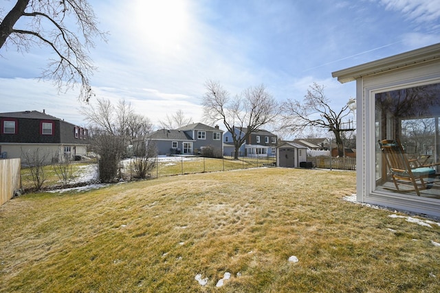 view of yard with a fenced backyard, a shed, an outdoor structure, and a residential view