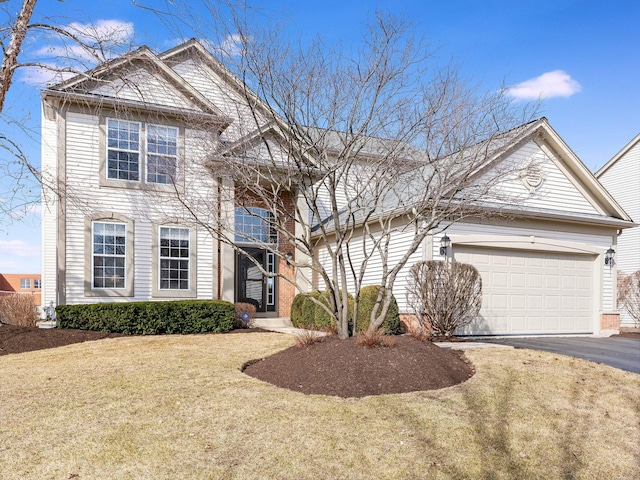 traditional-style house featuring a garage, a front lawn, and driveway