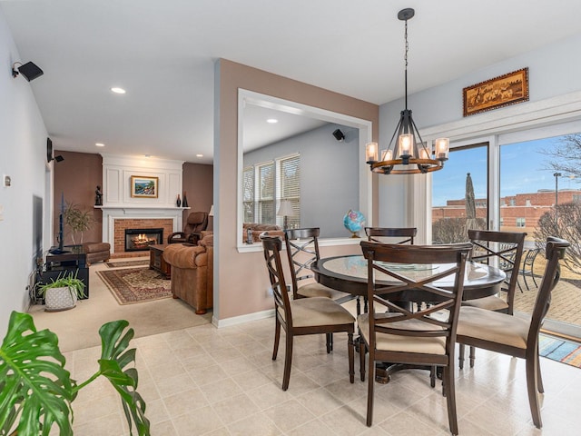 dining area featuring a chandelier, recessed lighting, a brick fireplace, and baseboards