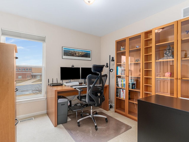 office area featuring visible vents, light colored carpet, and baseboards