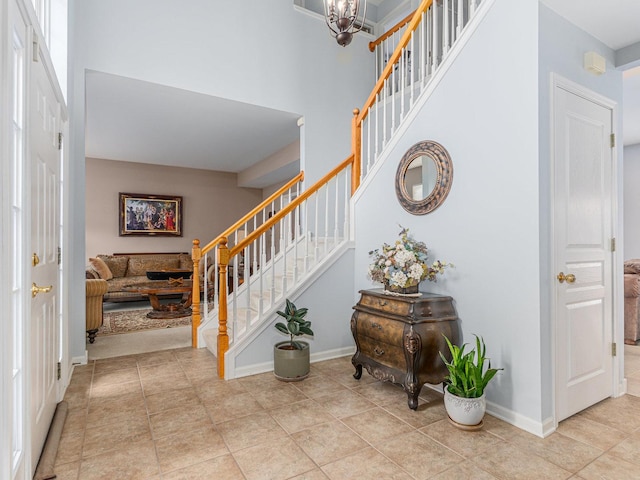 stairway featuring a high ceiling and baseboards