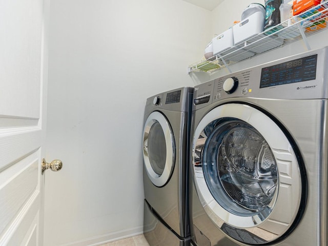 clothes washing area with washer and clothes dryer, laundry area, and baseboards