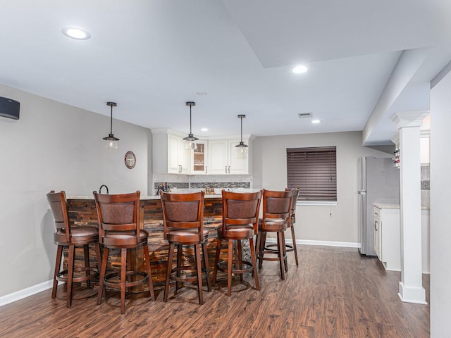 bar featuring recessed lighting, decorative backsplash, dark wood-style flooring, and freestanding refrigerator